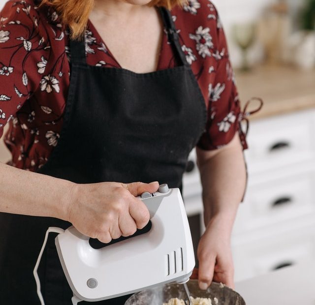 Gambar perempuan sedang menggunakan hand mixer